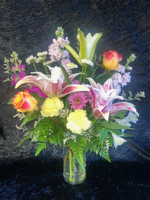 Beautiful bouquet filled with Double Lillies, Yellow Carnations, Purple Daisies and White Alstro.